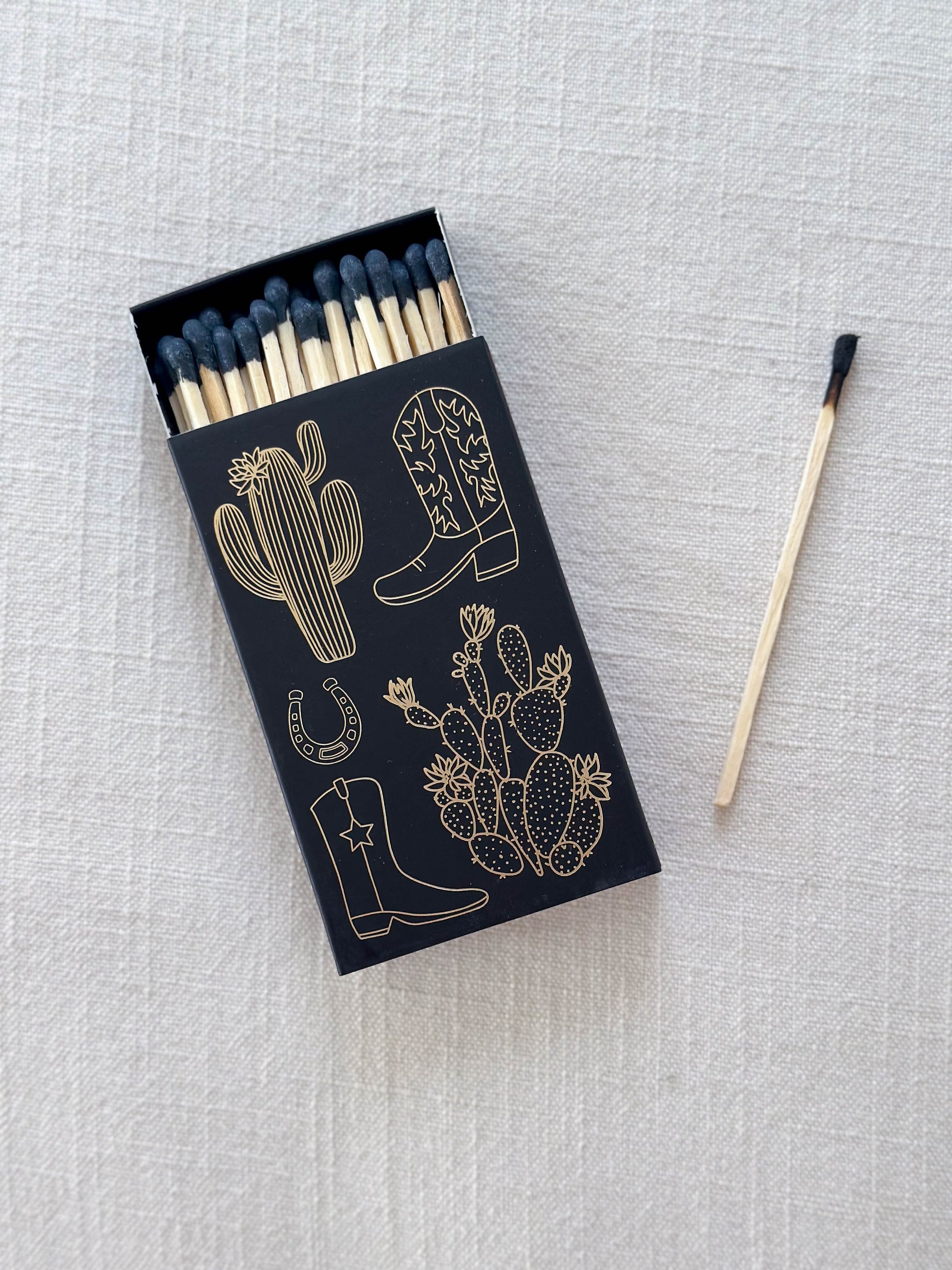 4" black tipped safety matches inside a cowboy boot and cactus box.